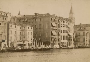 Photo of the grand hotels on the canal bank with a row of gondolas 