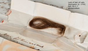 Lock of brown hair kept folded in paper