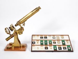 Gold microscope and a slideholder from a box of specimen slides 