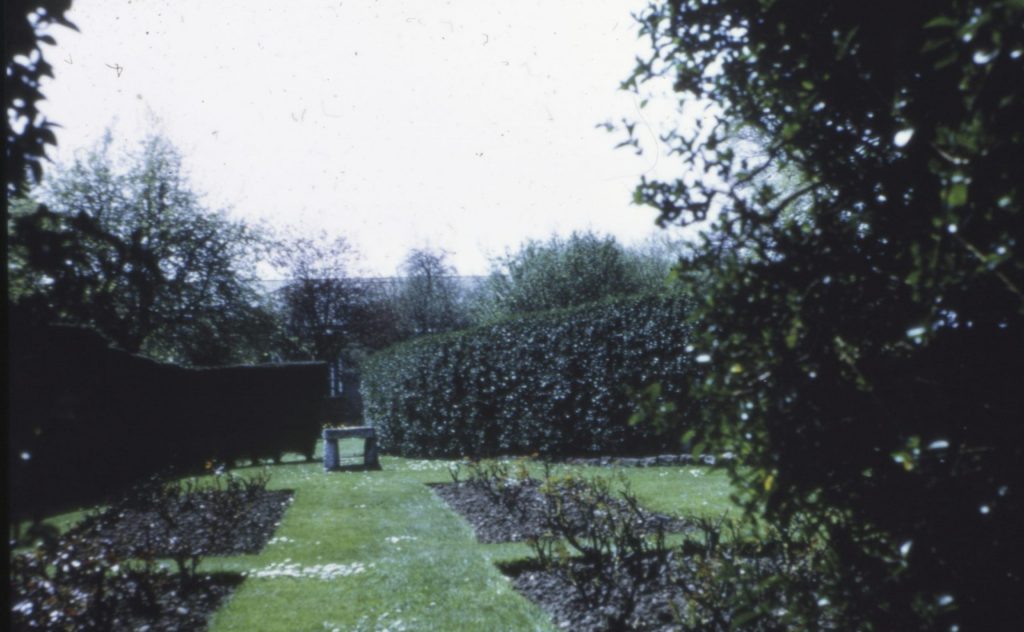 Photograph of gardens including trees, hedges and flower beds.