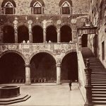 A sepia photograph of a courtyard and staircase at Palazzo Vecchio , Florence