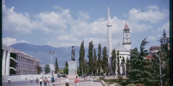 A colour photograph of Skanderbeg Square, Tirana showing trees, monuments and buildings.