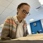 Volunteer Jessica looking at a handwritten document in the Manuscripts and Special Collections Reading Room