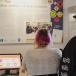 Attendees looking at one of the exhibition boards.