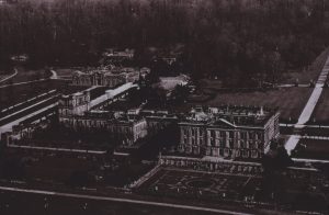 A glass slide showing an aerial view of a manor house. 