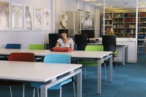 Image of a woman consulting a book in the Manuscripts and Special Collections Reading Room. 