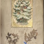 A page with the following items stuck on to it: two leaves and a card featuring an image of birds in a tree with a golden border.