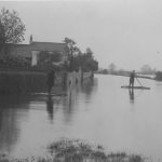Black and white photographs of men on rafts on the flooded River Trent, Nottingham.
