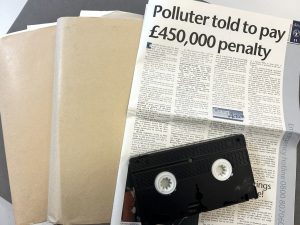 Photograph of file, article and VHS video tape.