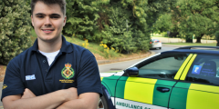 James Conlan smiling at the camera next to a community ambulance