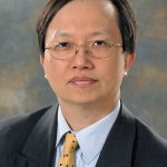 Professor Kwok-Leung Cheung smiling at the screen