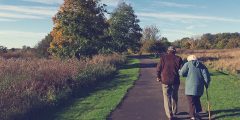 An elderly couple walking along a rural path