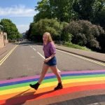 Imogen Hullis smiling and walking across the Pride crossing