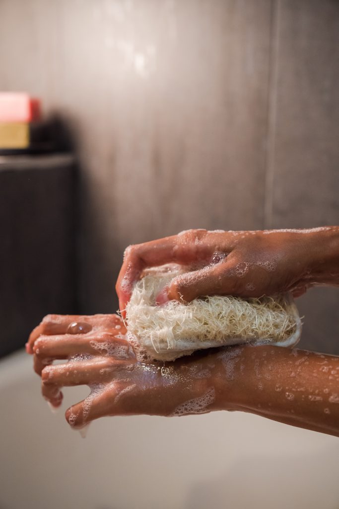 A person washing their hands with a sponge