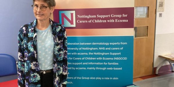 Amanda Roberts standing next to a stand with information about the Nottingham Support Group for Carers of Children with Eczema