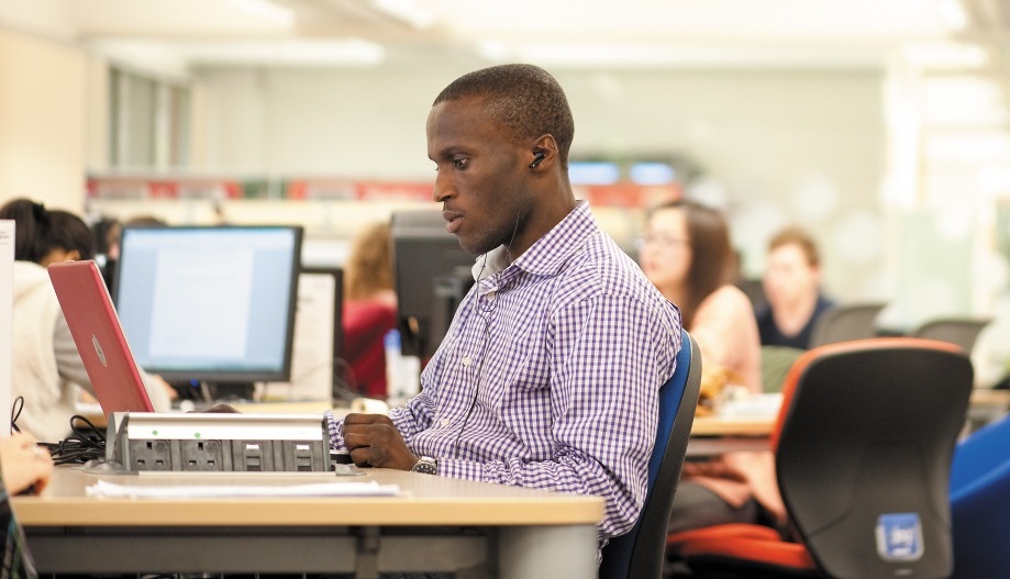 Male postgraduate student studying in Hallward Library, University Park