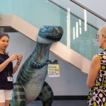 Ruth Griffin and Dame Jessica in the BiioDiscovery Institute, the image includes an inflatable dinosaur which has a social distancing message