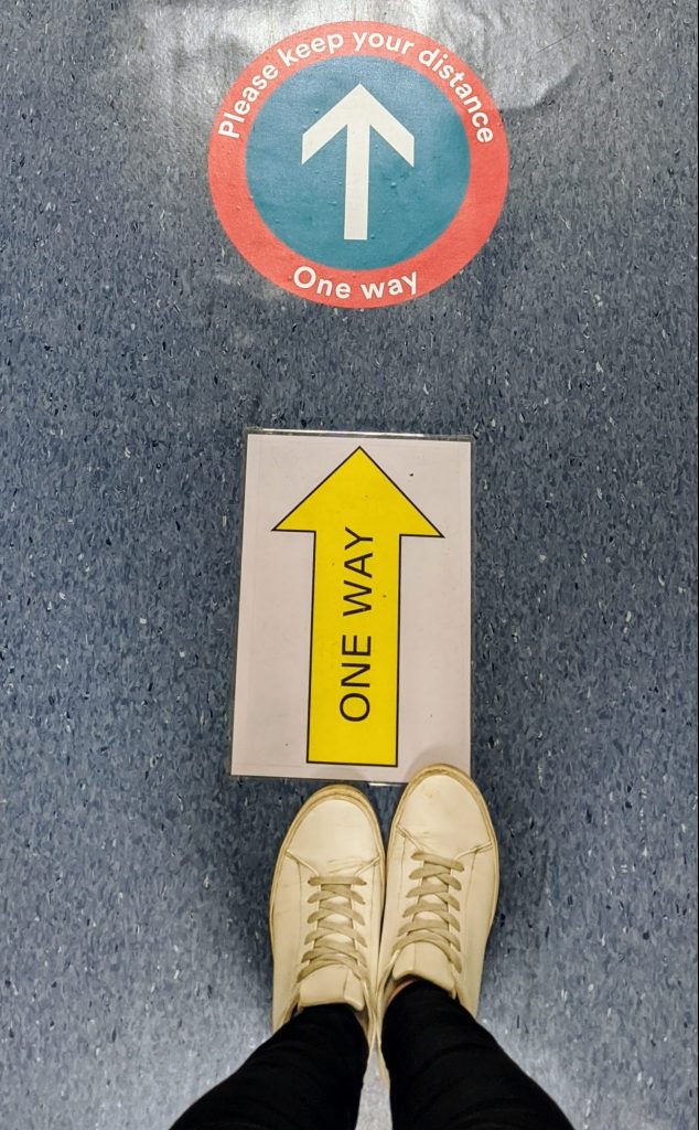 Social distancing signs on the floor of a lab
