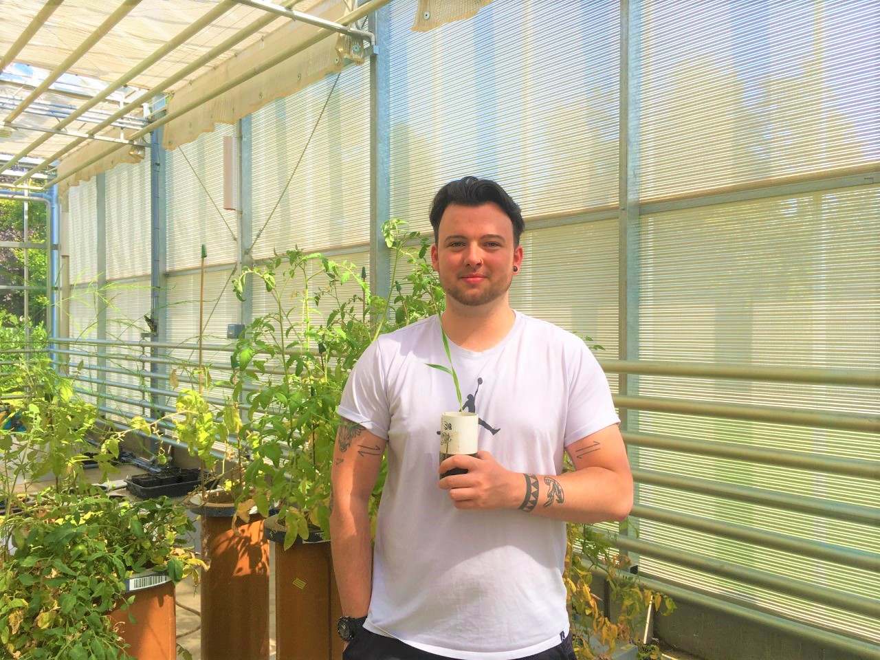 Sam Booth with a plant in the Hounsfield Facility