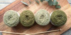 Four balls of yarn and wooden knitting needles