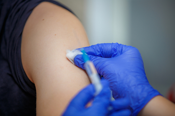 A person recieing a vaccine in their shoulder