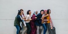 A group of diversely cultured women standing in a queue for the picture. They all seem happy and comfortable around each other.