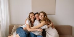 Group chats - three women sat hugging on a sofa