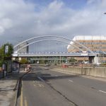 Day time picture of the Ningbo Friendship Bridge over the A52 road, with Queen's Medical Centre in the background.