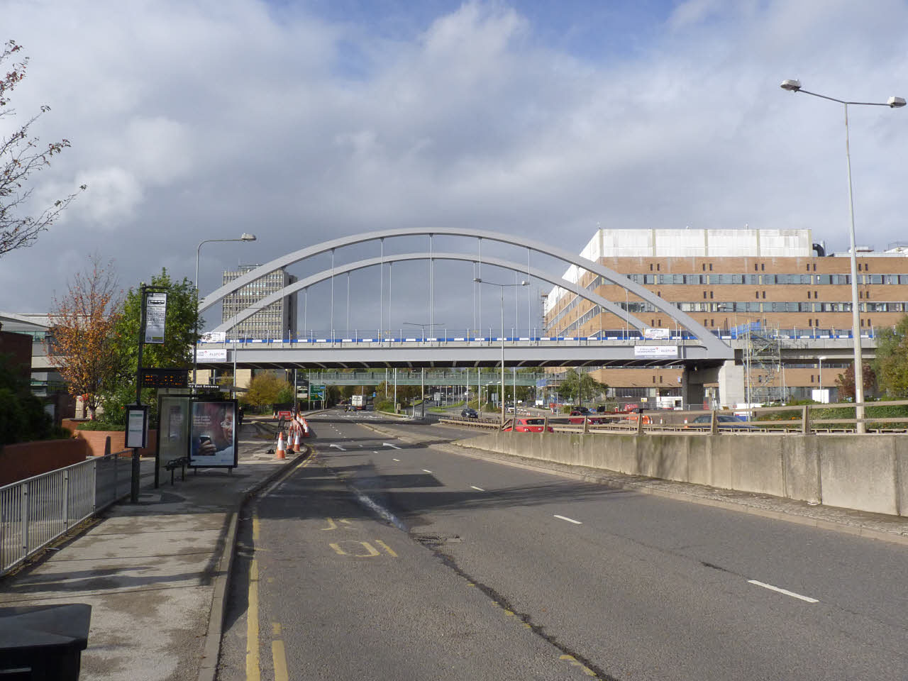 Day time picture of the Ningbo Friendship Bridge over the A52 road, with Queen's Medical Centre in the background.
