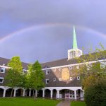 A rainbow over Rutland, a catered student hall. The top of the spire appears to be touching the rainbow.