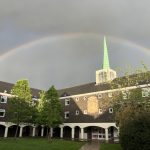 A rainbow over Rutland Hall. The building's spire appears to touch the rainbow.