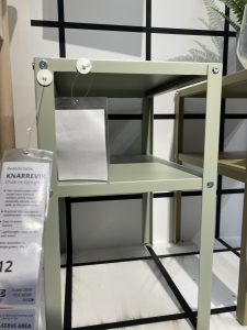 This photo was taken in Ikea, and it is of a green metal bedside table. The price tag is just visible, and it reads £12