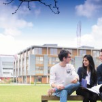 Three postgraduate students studying in front of Business School North, Jubilee campus