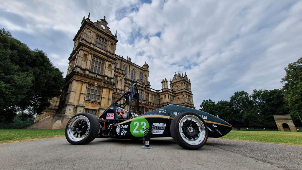 A racing EV in front of a historic house