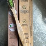 A bamboo toothbrush on recyclable packaging