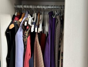 A wardrobe door ajar revealing a rack of clothes